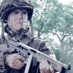 Ronald Speirs (Matthew Settle) pointing a gun in Band of Brothers.