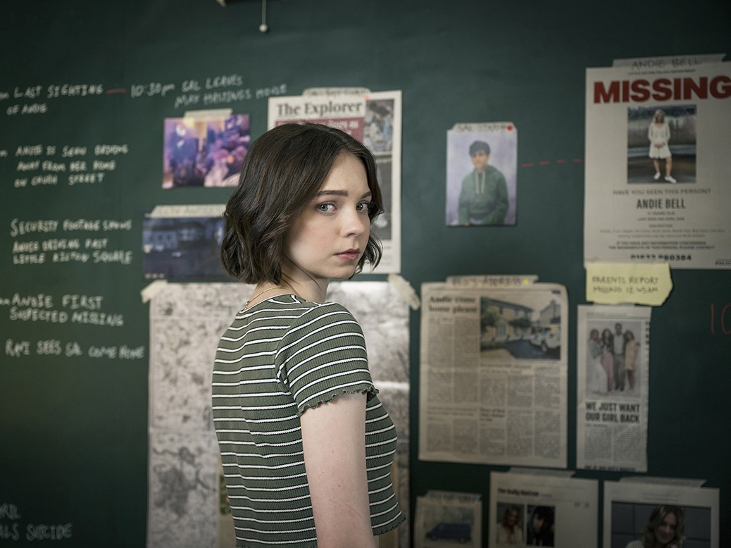 Emma Myers as Pip in A Good Girl's Guide to Murder BBC adaptation, intently examining evidence on a blackboard.