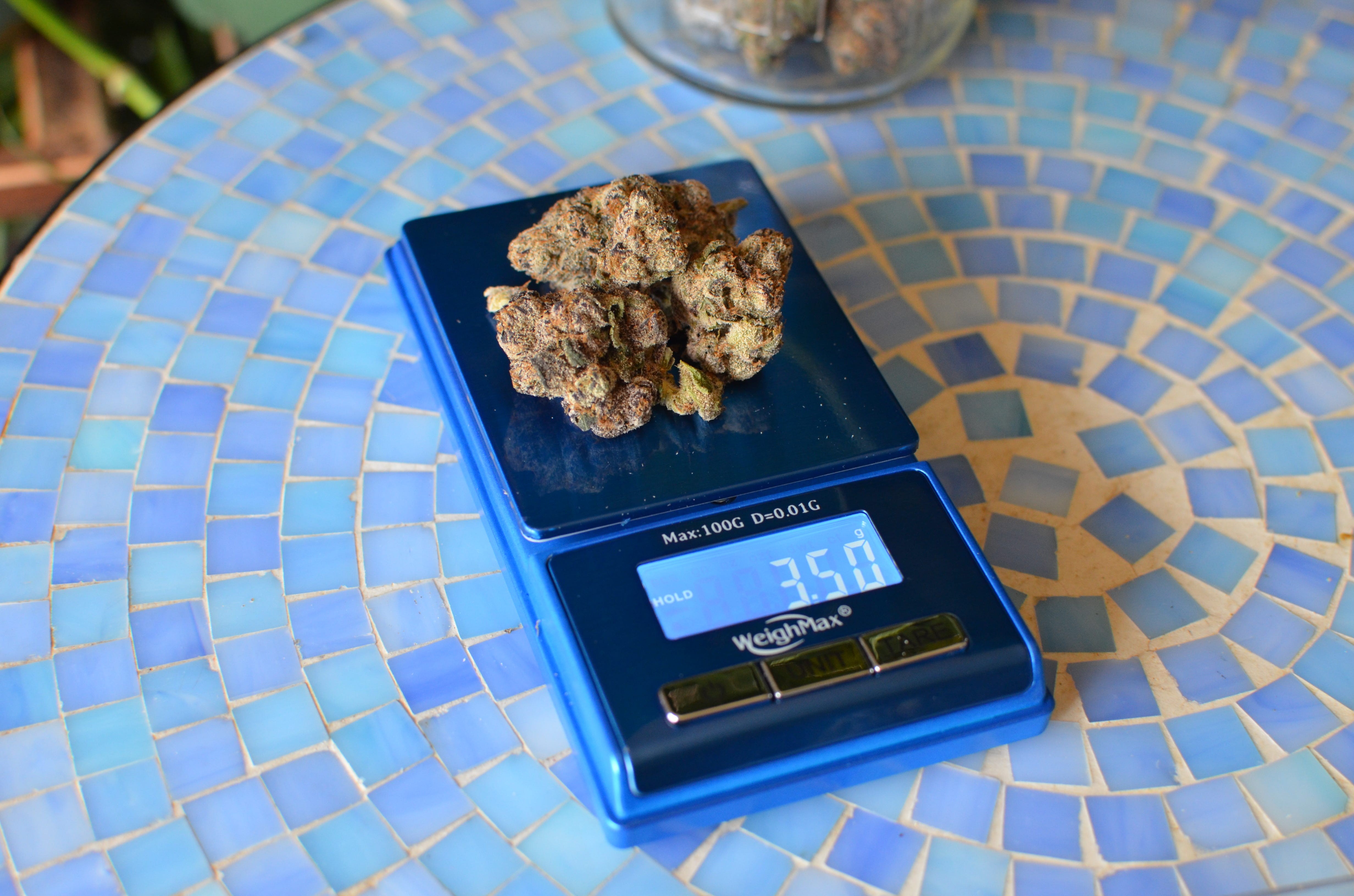 An eighth of cannabis flower, displayed as a small pile of buds.