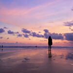 Sunset at Double Six Beach in Seminyak with vibrant orange and purple hues reflecting on the wet sand