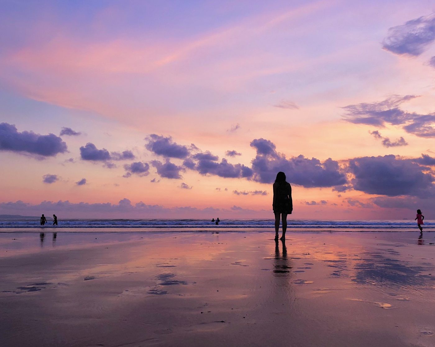 Sunset at Double Six Beach in Seminyak with vibrant orange and purple hues reflecting on the wet sand