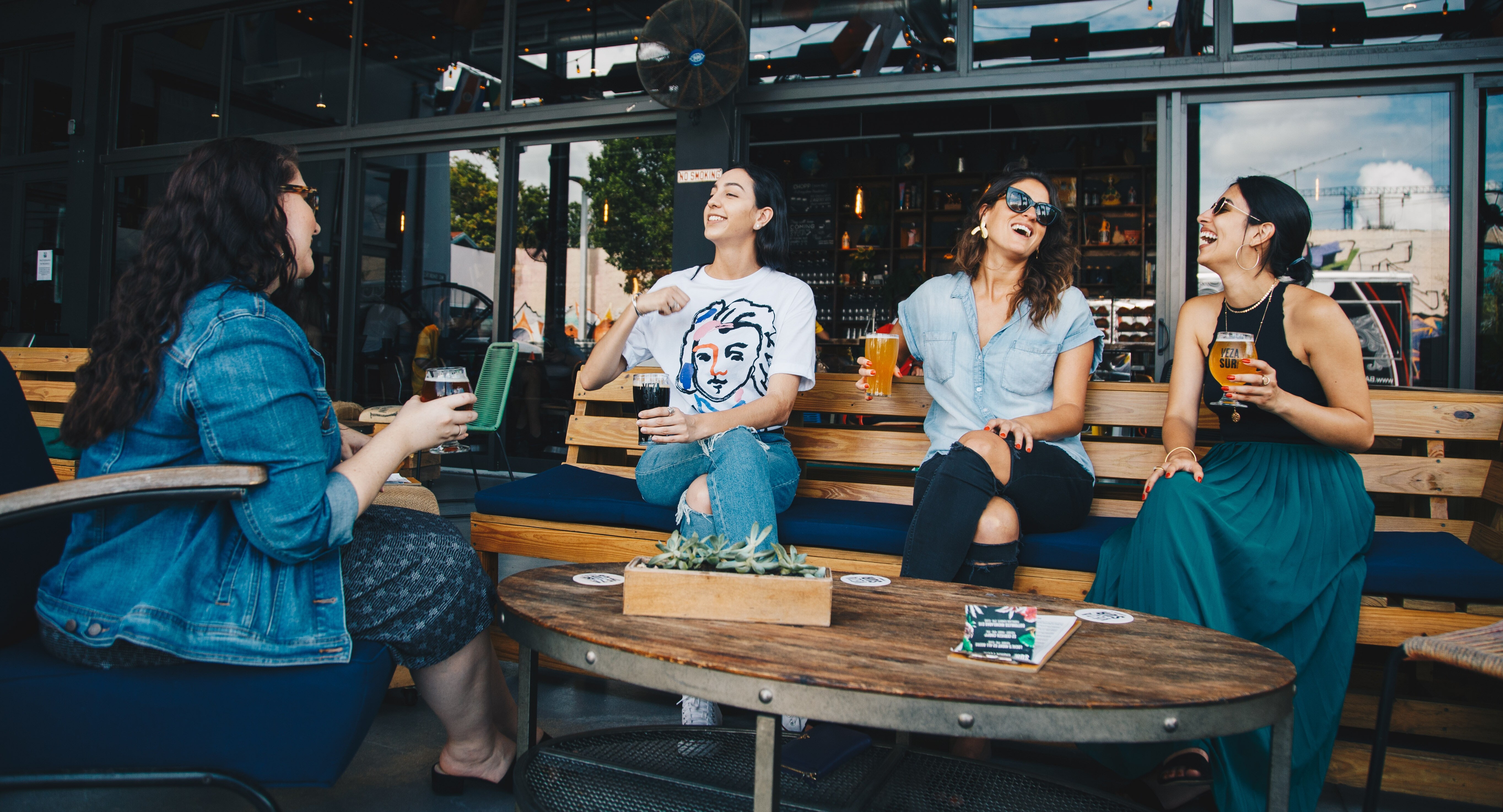 Four women engaging in a lively book club discussion, highlighting the joy of shared reading experiences