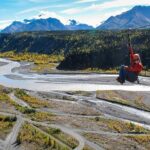 A person is ziplining over a valley in Alaska, showcasing the Nitro zipline experience with MICA Guides.