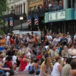 Crowd Of People Sitting In Front Of A Theatre