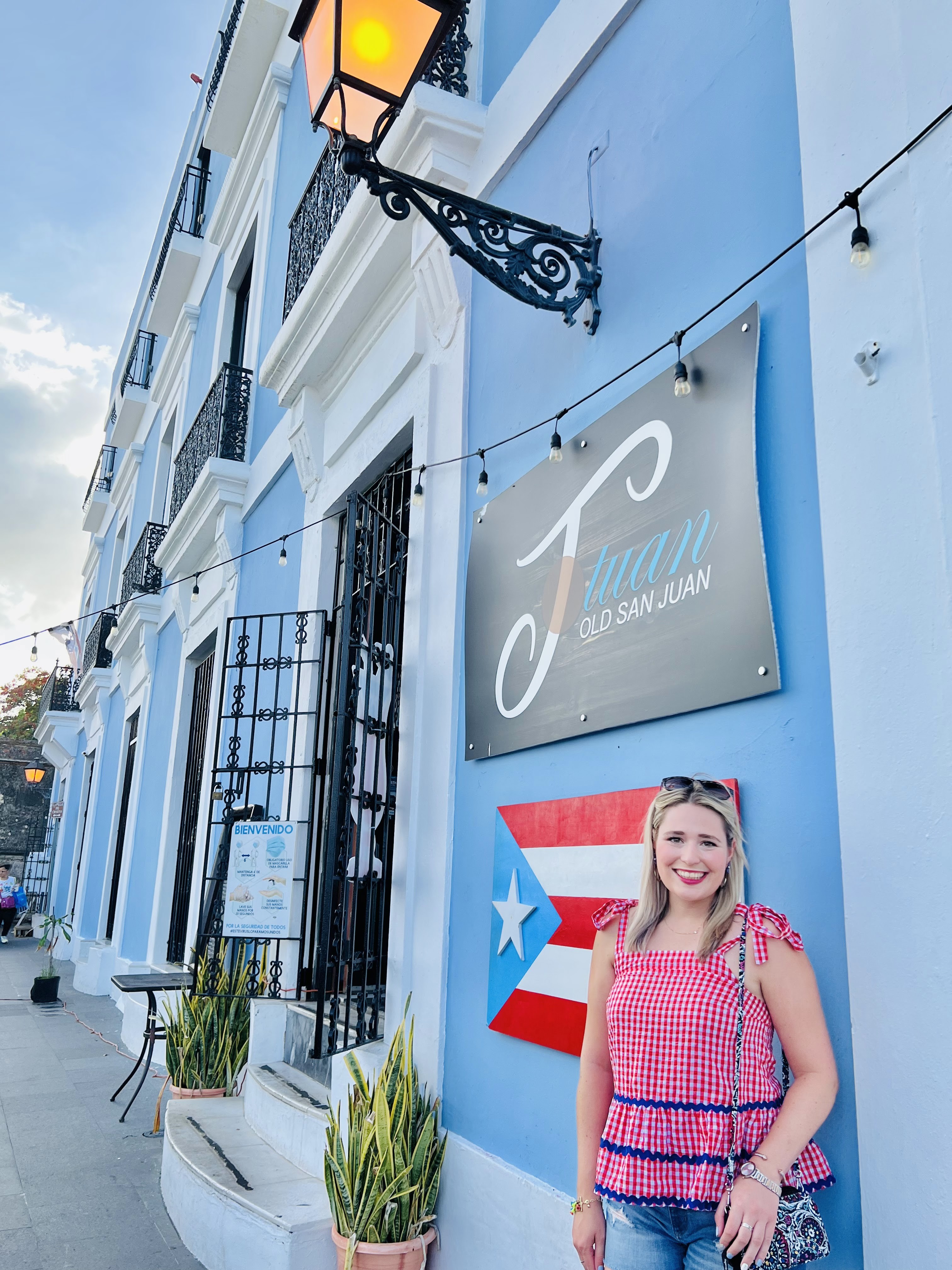 A picturesque corner in Old San Juan with blue colonial buildings and lush plants