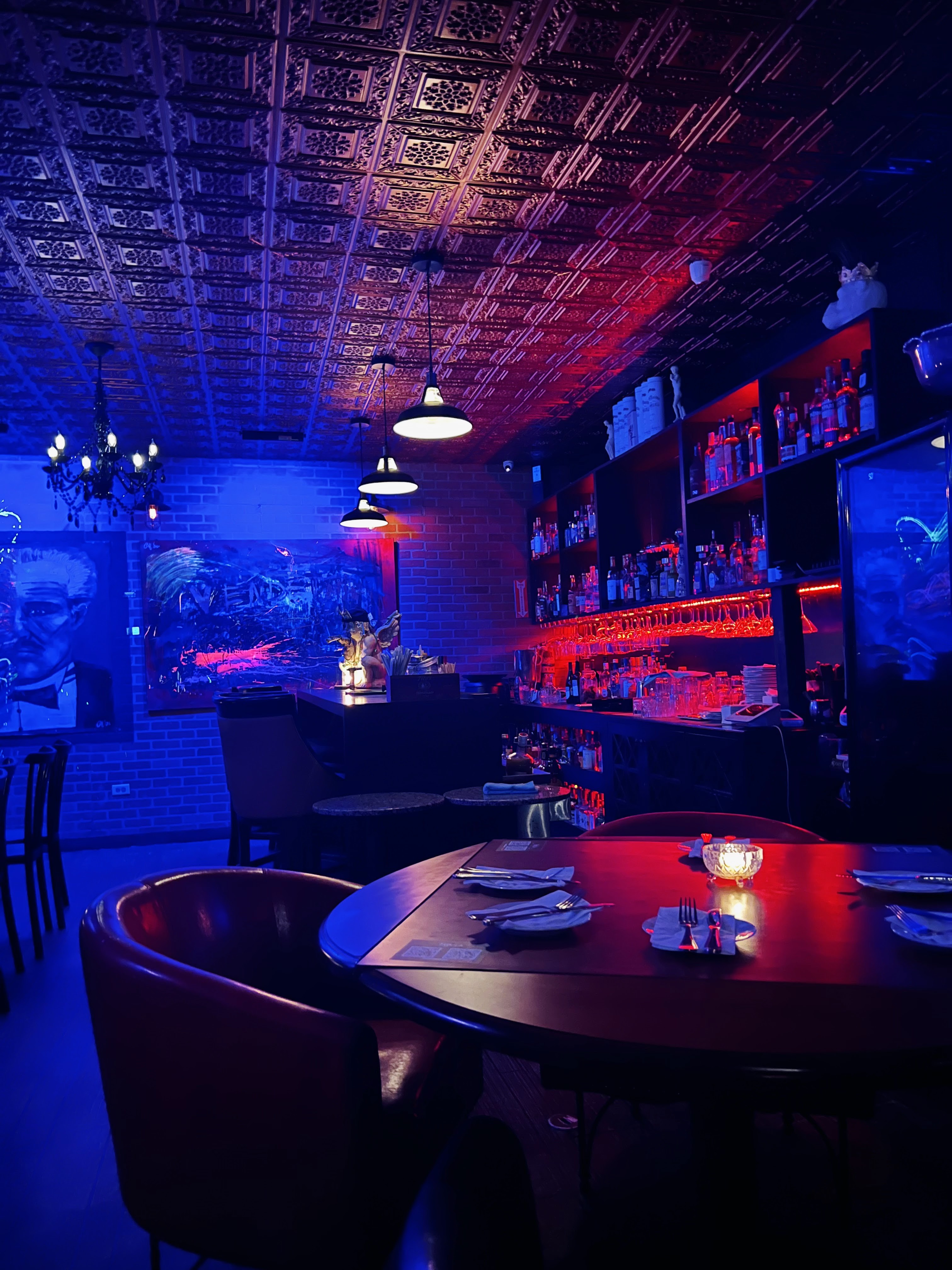 A group of people dining in the dimly lit, speakeasy dining area of Tavola restaurant in San Juan