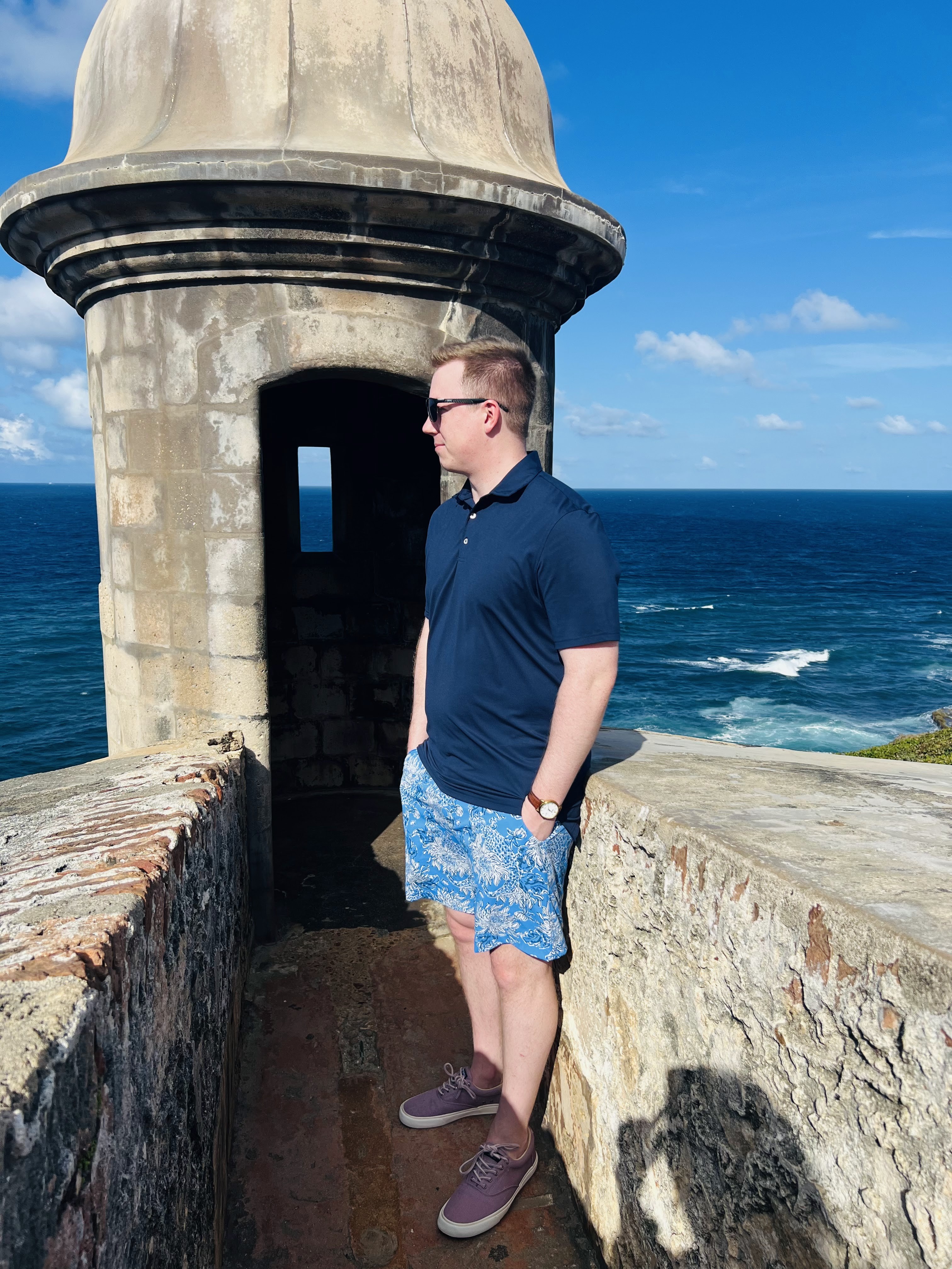 People exploring the grounds of San Juan National Historic Site with historic buildings and ocean views