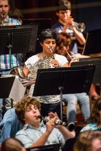 A young musician intensely focused on playing their instrument, highlighting the dedication required for musical learning.