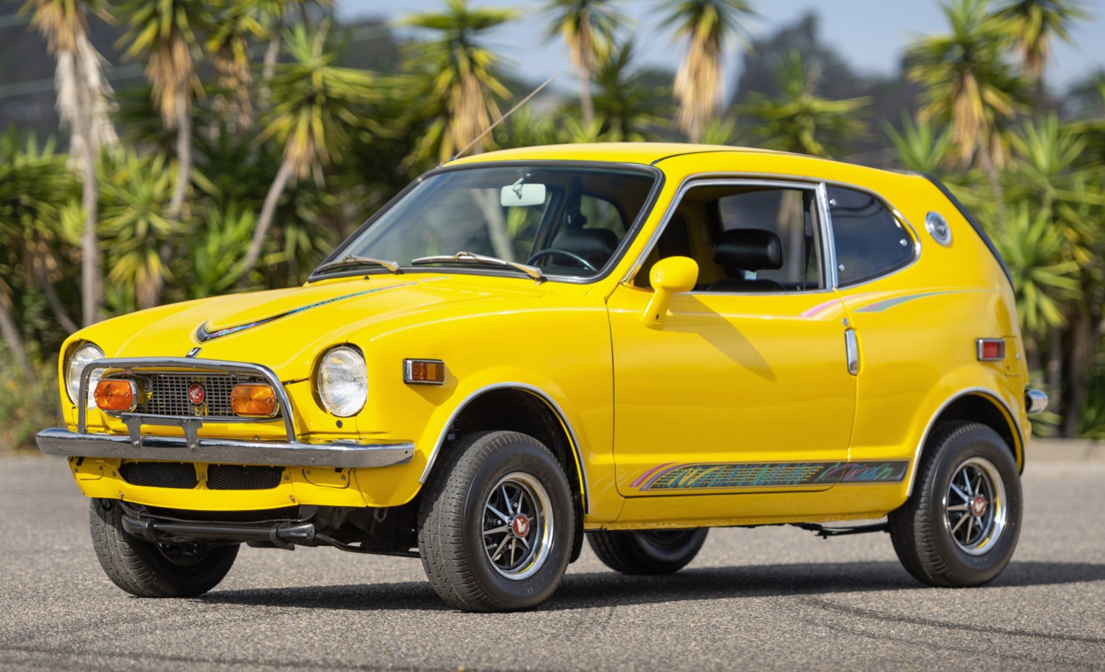 Front three-quarter view of a yellow 1972 Honda Z600 at Monterey Car Week auction, highlighting Hagerty Price Guide surprises.