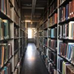 A narrow aisle of Dartmouth library stacks, filled with books on both sides