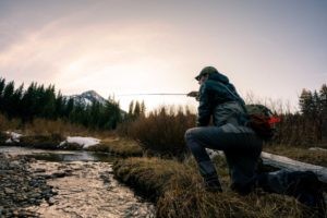 Fly fisherman wears Smith Guide