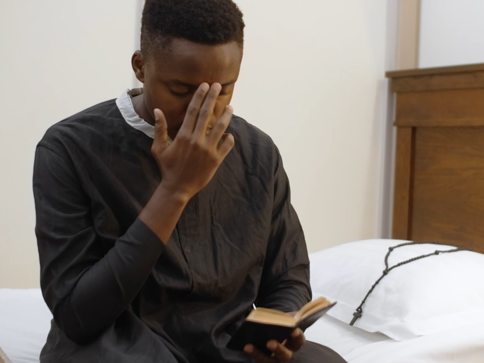 A person making the Sign of the Cross, a traditional Christian gesture of faith.