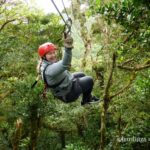 A girl ziplining through the rainforest canopy in Monteverde, Costa Rica