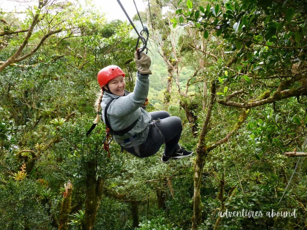 A girl ziplining through the rainforest canopy in Monteverde, Costa Rica