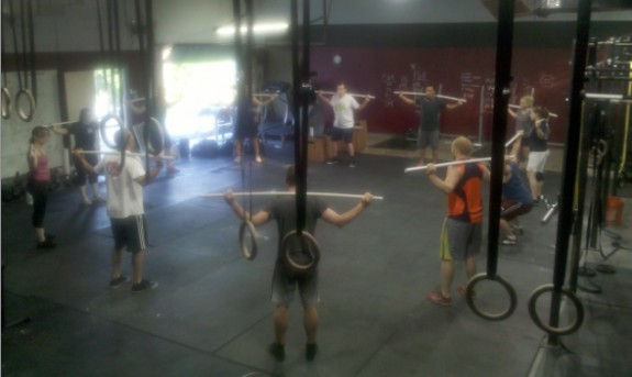 People in the middle of a CrossFit workout, demonstrating the communal and intense nature of the fitness regimen